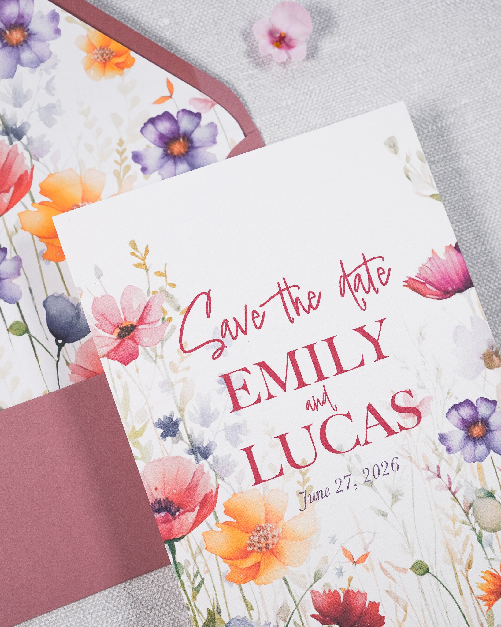 Close up of a wedding Save The Date card in a garden print. Matched with a rose pink envelope