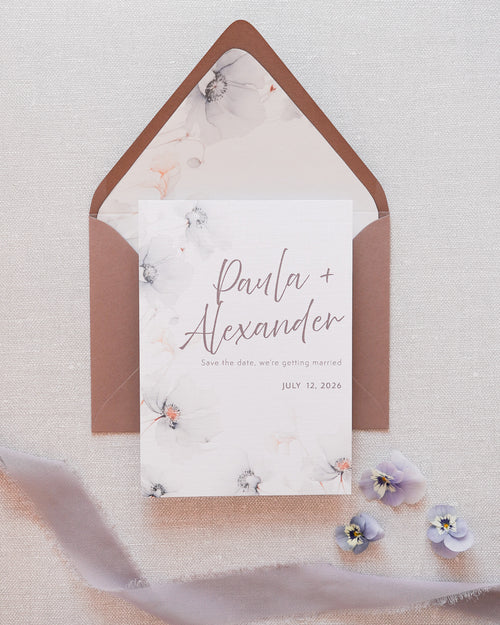 A save the date card in a grey floral print. Matched with a grey envelope with a floral printed liner.
