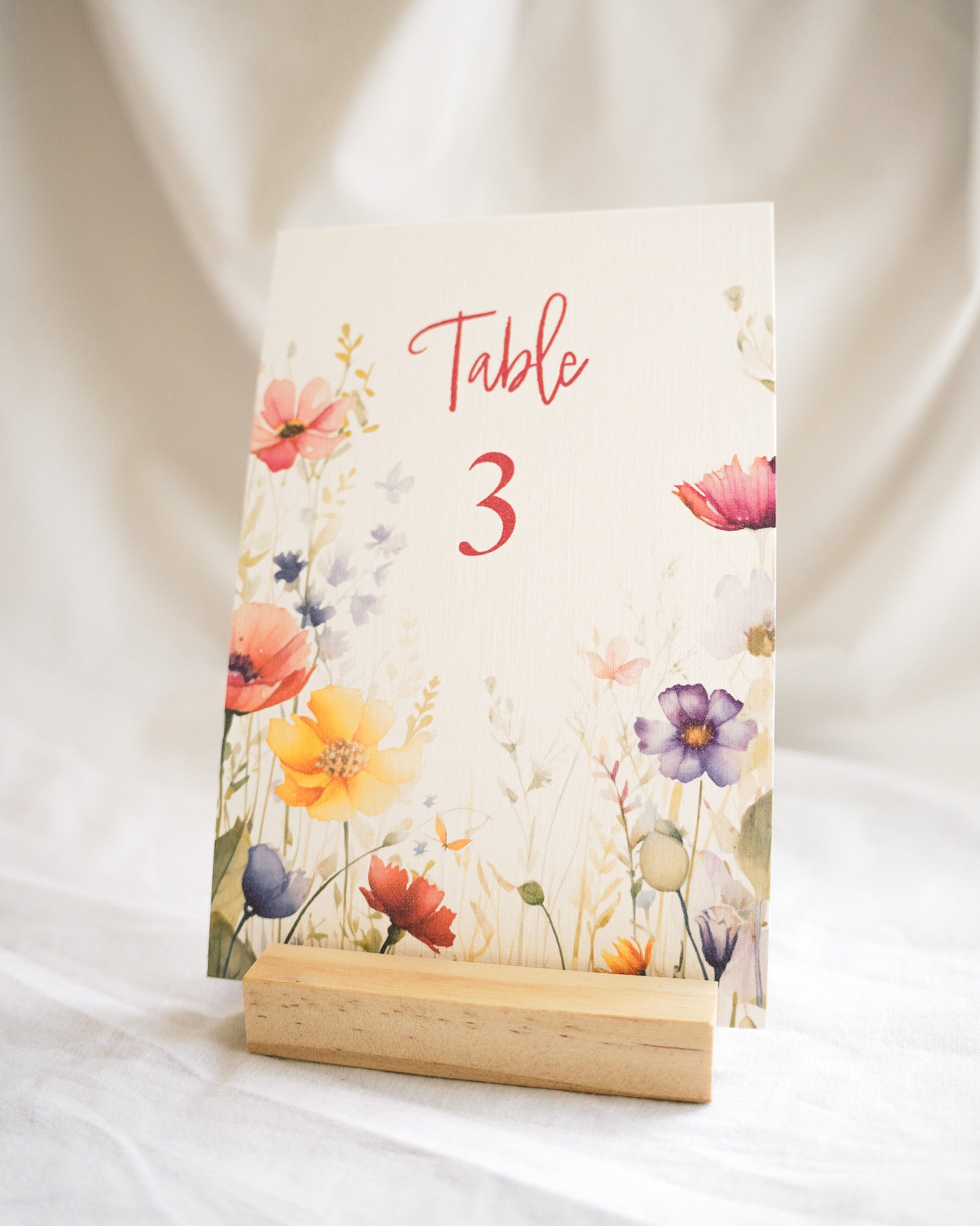 a sign with table numbers for weddings. A handpainted floral pattern