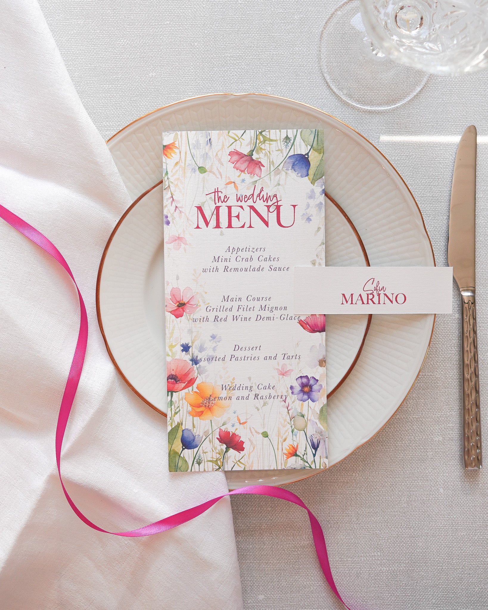 A handmade wedding menu card with matching placecard. The menu is in a bright pink floral print.