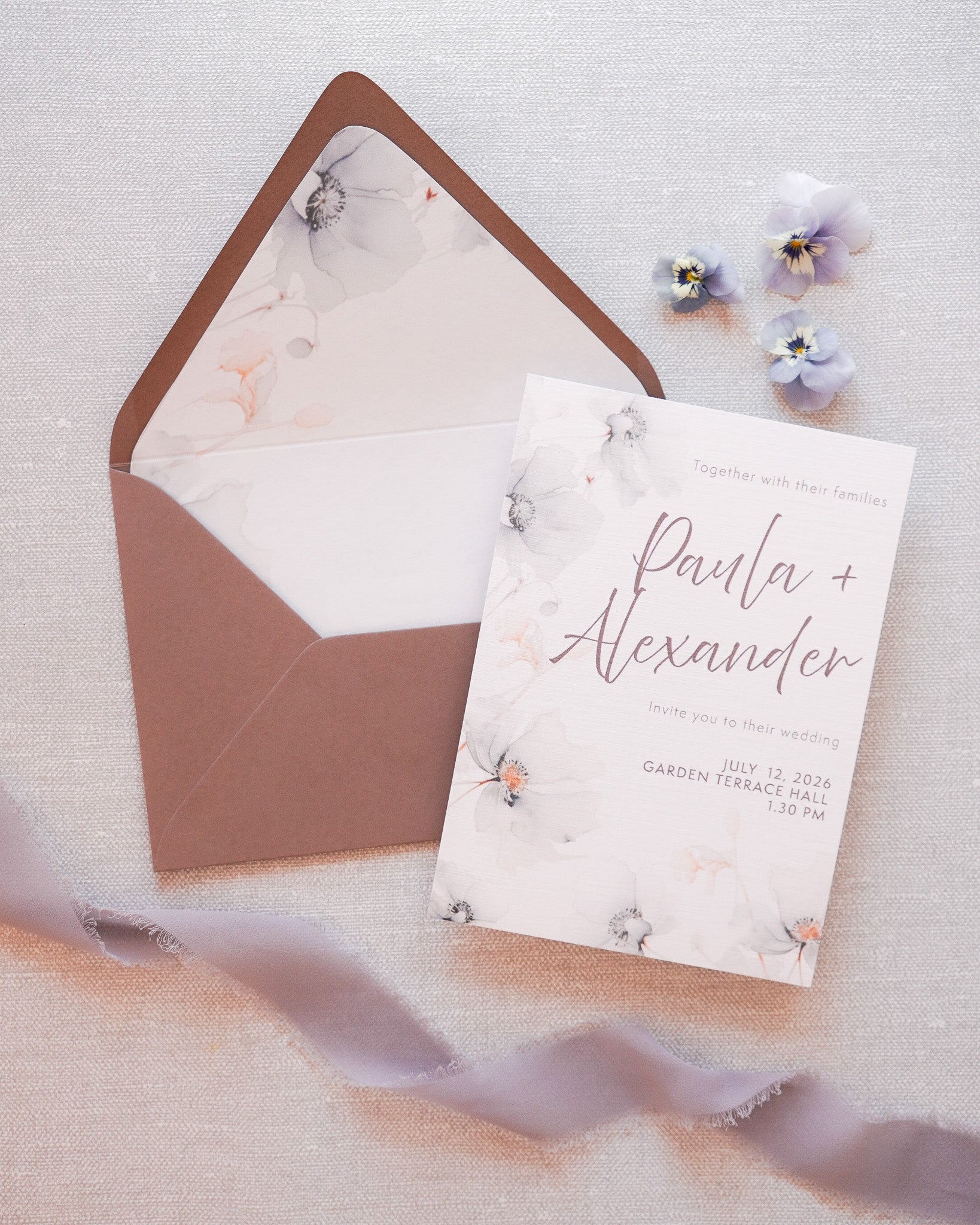 A wedding invitation with a soft floral pattern. Combined with a grey envelope with a printed liner. 